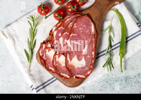 Pastrami de bœuf à la ribeye. Tranches de bacon turc séché sur une table de service en bois. Spécialités turques traditionnelles. Nom local pastirma. Vue de dessus Banque D'Images