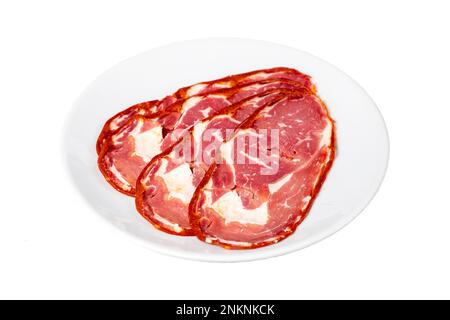 Pastrami de la ribeye de bœuf isolé sur fond blanc. Tranches de bacon turc séchées dans l'assiette. Spécialités turques traditionnelles Banque D'Images