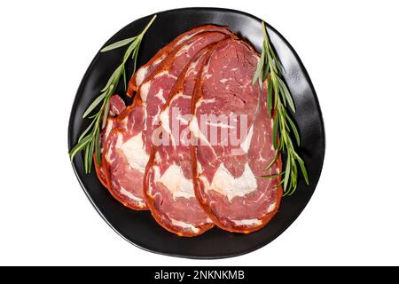 Pastrami de la ribeye de bœuf isolé sur fond blanc. Tranches de bacon turc séchées dans l'assiette. Spécialités turques traditionnelles. Vue de dessus Banque D'Images