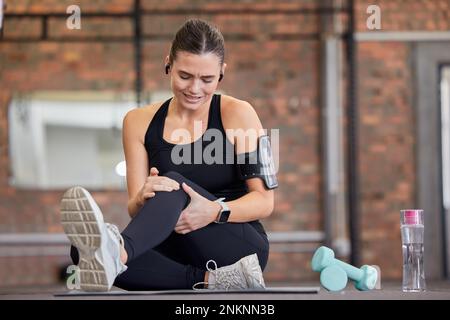 Douleurs au genou, fitness et femme avec blessure en salle de gym après accident, séance d'entraînement ou entraînement. Sports, santé et jeune athlète féminine avec fibromyalgie Banque D'Images