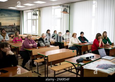 Les gens écoutent en tant que membre de la Fiducie Halo tient une leçon éducative aux enseignants sur le défrichement de l'ordonnance des mines terrestres, pour informer et éduquer sur les risques et ce qu'il faut faire quand on se trouve à Irpin. Les membres de la Fiducie Halo enquêteront et défriront sur les mines dangereuses potentielles et les matières contaminées à la périphérie de Kiev, une zone précédemment occupée par les troupes russes, à Kiev, en Ukraine, avant le premier anniversaire vendredi de l'invasion russe de l'Ukraine. Date de la photo: Mercredi 22 février 2023. Banque D'Images