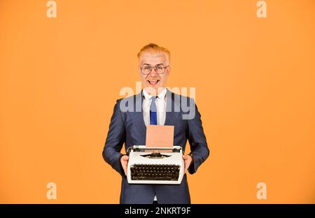 L'écrivain colle de vieilles habitudes. Magasin de produits d'occasion. Objets vendeurs vintage. Connaisseur des valeurs millésières. Machine à écrire vintage. Homme d'affaires utilise un technolo rétro Banque D'Images