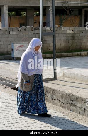 OVAKENT,HATAY,TURQUIE-DÉCEMBRE 10:une ancienne femme ouzbek non identifiée avec le hijab blanc marchant dans la rue. 10 décembre, 2016, Ovakent, Hatay, Turquie Banque D'Images