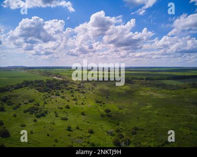 Splendide photographie aérienne de champs ondulés verts par temps ensoleillé. Vue de dessus tir de drone. Zone agricole de l'Ukraine, Europe. Concept de l'industrie agraire. Banque D'Images