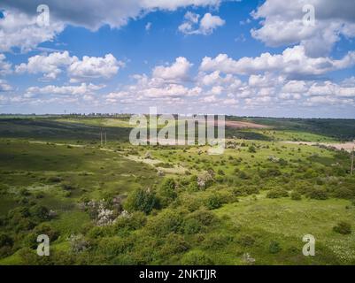 Splendide photographie aérienne de champs ondulés verts par temps ensoleillé. Vue de dessus tir de drone. Zone agricole de l'Ukraine, Europe. Concept de l'industrie agraire. Banque D'Images