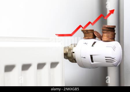 Augmentation des factures d'énergie. Flèche rouge montante et pièces sur un radiateur de chauffage. Crise du coût de la vie. récession inflation concept copy space Banque D'Images
