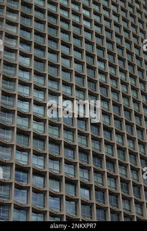 Immeuble de bureaux de style moderniste - fenêtres en verre répétées d'un gratte-ciel avec bords en béton. Fond, texture, papier peint moderniste gratte-ciel Banque D'Images