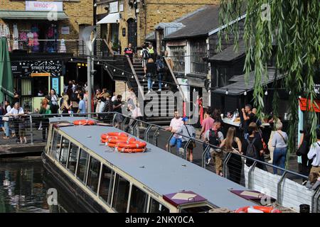 Un après-midi d'été chaud au populaire marché Camden Lock avec des gens qui font du shopping, achètent le déjeuner, se détendent et pendent avec des amis Banque D'Images