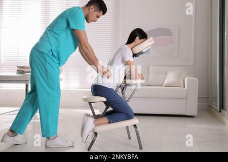 Femme recevant un massage dans une chaise moderne à l'intérieur Banque D'Images