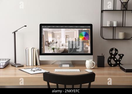 Le lieu de travail du concepteur. Ordinateur avec application d'édition de photos sur table à l'intérieur Banque D'Images