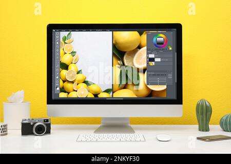 Le lieu de travail du concepteur. Ordinateur avec application photo Editor sur table Banque D'Images