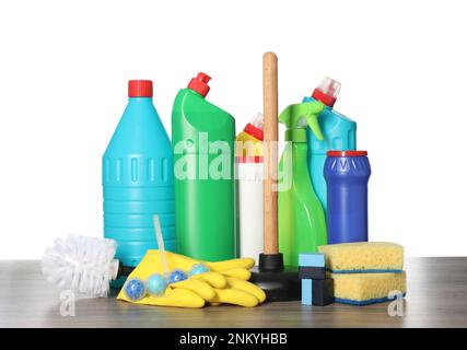 Différentes fournitures et outils de nettoyage de toilettes sur une table en bois sur fond blanc Banque D'Images