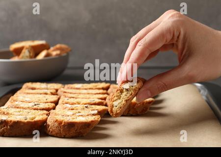 Femme prenant le biscuit traditionnel italien d'amande (Cantucci) de la plaque de cuisson, gros plan Banque D'Images