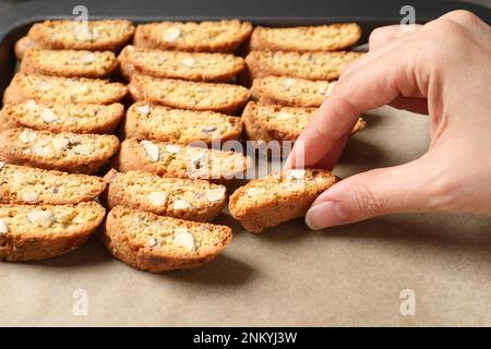 Femme prenant le biscuit traditionnel italien d'amande (Cantucci) de la plaque de cuisson, gros plan Banque D'Images