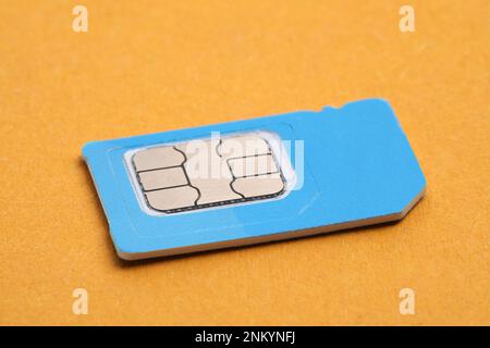 Mini carte SIM sur fond orange, gros plan Banque D'Images