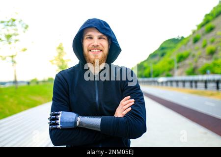 homme avec prothèse de bras dans des vêtements de sport prêts pour l'entraînement matinal à l'extérieur.Concept de sport pour handicapés Banque D'Images