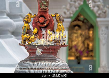 Ancienne fonte d'une créature mystique, moitié humaine moitié animal, décorée sur la cloche de fer supérieure avec une pagode blanche floue et statue de Bouddha doré dans le TH Banque D'Images