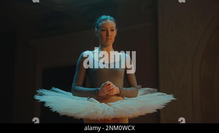 Réalisation cinématographique d'une ballerine gracieuse dans une robe de ballet debout dans le hall du théâtre après la répétition de chorégraphie, en regardant la caméra. Belle danseuse de ballet avant la représentation. Art classique du ballet Banque D'Images