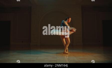 Prise de vue cinématique de la magnifique danseuse de ballet classique en robe tutu blanche dansant dans le hall du théâtre et préparant le début de la représentation. Chorégraphie avant le début du spectacle. Art classique du ballet Banque D'Images