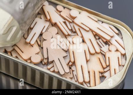 En bois découpé au laser, de forme mâle et femelle, emballé dans une boîte de sardine métallique. Pour les gens emballés comme des sardines, écrasées ensemble, pas assez de place pour bouger. Banque D'Images