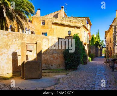 Rues pavées et maisons ornées de plantes dans le centre historique de la Bisbal en Catalogne, Espagne. Banque D'Images