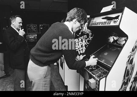 Pays-Bas Histoire : les passagers d'avions attendent leurs vols pour jouer à des jeux vidéo et à des flippers à Schiphol. Ici, un homme joue le jeu vidéo Phantom II de Midway Companyl CA. 18 janvier 1980 Banque D'Images