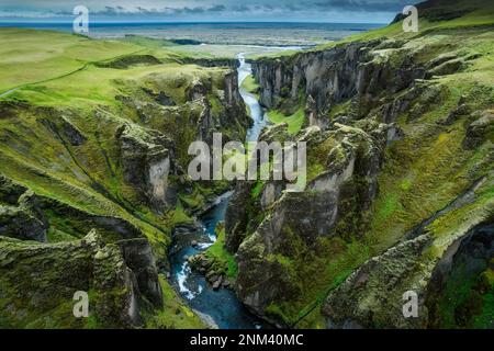 Vue aérienne stupéfiante du canyon de Fjadrargljufur naturellement érodé avec Fjadra qui coule à travers le ravin en été en Islande Banque D'Images