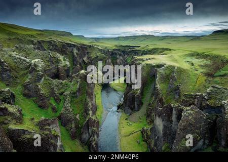 Vue aérienne stupéfiante du canyon de Fjadrargljufur naturellement érodé avec Fjadra qui coule à travers le ravin en été en Islande Banque D'Images