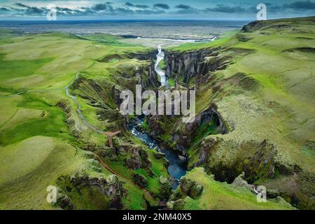 Vue aérienne stupéfiante du canyon de Fjadrargljufur naturellement érodé avec Fjadra qui coule à travers le ravin en été en Islande Banque D'Images