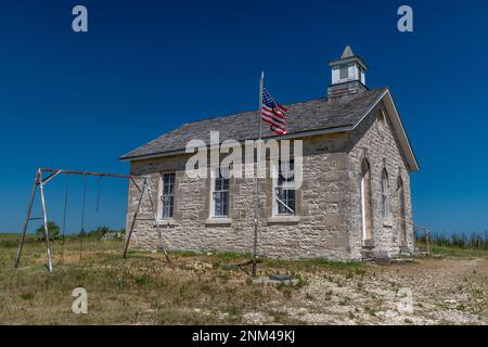 Une belle vieille école historique avec drapeau et jeu encore debout sur la prairie du Kansas. Banque D'Images