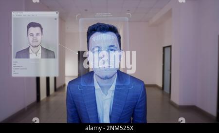 L'homme d'affaires scanne la face au bureau. Il touche le capteur et identifie le système de sécurité. 3D hologramme de reconnaissance faciale biométrique humaine et profil virtuel personnel. Identification et technologie de l'IA. Banque D'Images