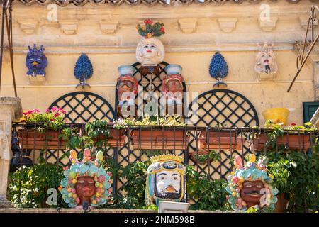 À Palazzolo Acrède, Italie , le 03 - 08 - 2022 - têtes de moor en céramique traditionnelle et cônes de pin sur un balcon baroque, Sicile, Italie Banque D'Images