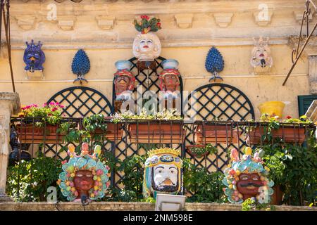 À Palazzolo Acrède, Italie , le 03 - 08 - 2022 - têtes de moor en céramique traditionnelle et cônes de pin sur un balcon baroque, Sicile, Italie Banque D'Images