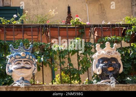 À Palazzolo Acrède, Italie , le 03 - 08 - 2022 - têtes de moor en céramique traditionnelle et cônes de pin sur un balcon baroque, Sicile, Italie Banque D'Images