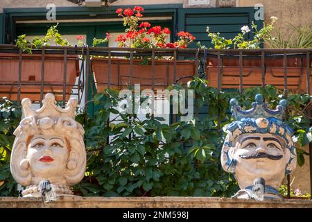 À Palazzolo Acrède, Italie , le 03 - 08 - 2022 - têtes de moor en céramique traditionnelle et cônes de pin sur un balcon baroque, Sicile, Italie Banque D'Images