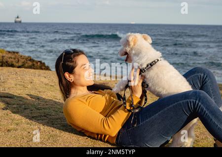 Jeune femme jouant avec son chien Banque D'Images