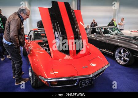 Londres, Royaume-Uni. 24th févr. 2023. Un passionné regarde une Corvette Stingray C3 avec le capot ouvert. Le London Classic car Show rassemble des véhicules automobiles emblématiques et classiques, attirant des collectionneurs et des passionnés dans les salles d'exposition de Kensington, Olympia. Credit: Imagetraceur/Alamy Live News Banque D'Images