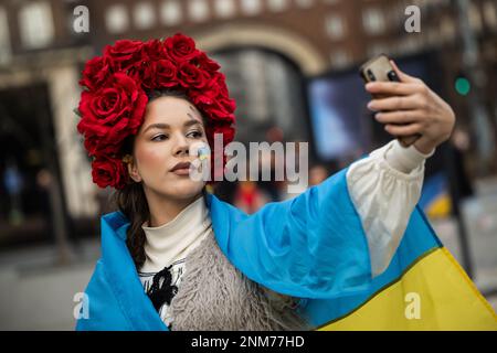 Budapest, Hongrie. 24th févr. 2023. Une femme prend une photo d'elle-même lors d'une marche de solidarité à l'occasion du premier anniversaire de l'invasion russe de l'Ukraine. L'armée russe avait envahi l'Ukraine le 24.02.2022. Crédit : Marton Monus/dpa/Alay Live News Banque D'Images