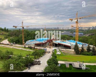 Chantier de construction, trois grues à tour haute et matériaux de construction bleus. Mémorial aux victimes de l'Holodomor en Ukraine. Une vue de la constructio Banque D'Images