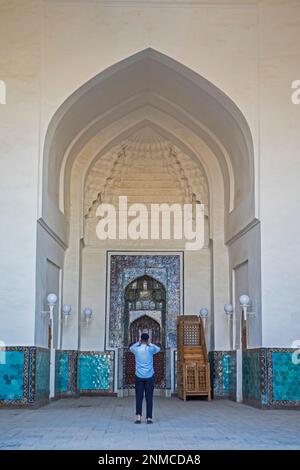 Homme priant devant mihrab, mosquée Kalon, Vieille Ville, Boukhara, Ouzbékistan Banque D'Images