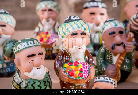 Les figurines en argile de professionnels de vieux hommes en costumes traditionnels de l'Ouzbek sont le meilleur cadeau de Khiva, Khiva, Ouzbékistan Banque D'Images