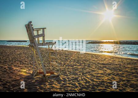 Chaise de maître nageur abandonnée en bois sur la plage avec tache solaire dans le ciel - Grands Lacs USA. Banque D'Images