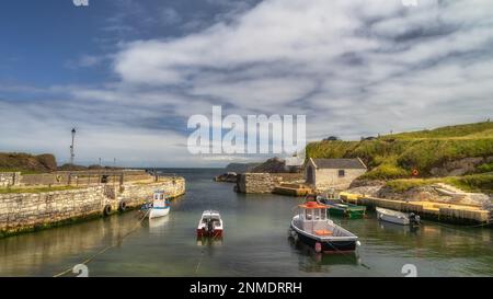 Magnifique petit port de Ballintoy avec jetée en pierre et bateaux amarrés sur la côte de Causeway, comté d'Antrim, Irlande du Nord Banque D'Images