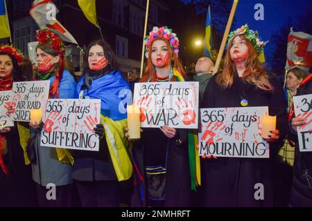 Londres, Royaume-Uni. 24th févr. 2023. Les manifestants portant des couvre-fleurs tiennent des bougies et des pancartes anti-guerre pendant la manifestation devant l'ambassade de Russie. Des milliers de personnes ont défilé de Holland Park à l'ambassade de Russie au cours d'une manifestation pro-ukrainienne à l'occasion du premier anniversaire de l'invasion russe. Crédit : SOPA Images Limited/Alamy Live News Banque D'Images