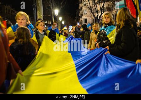 Barcelone, Espagne. 24th févr. 2023. Les manifestants arborent un drapeau ukrainien lors d'une marche marquant le 1st anniversaire de l'invasion russe de l'Ukraine et le début de la guerre Ukraine-Russie. La Russie a envahi l'Ukraine le 24th février 2022 dans ce que son président Poutine a appelé une « opération militaire spéciale ». Des milliers de personnes ont défilé dans la rue principale de Barcelone Passeig de Gracia pour protester contre la guerre. Crédit : SOPA Images Limited/Alamy Live News Banque D'Images