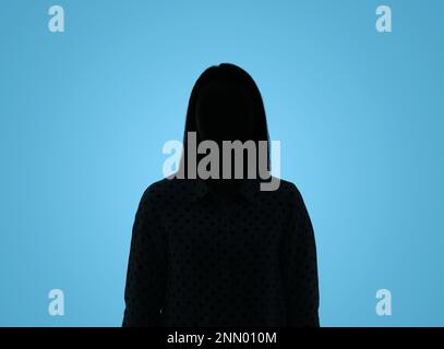 Silhouette de femme anonyme sur fond bleu clair Banque D'Images