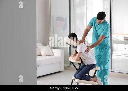 Femme recevant un massage dans une chaise moderne à l'intérieur Banque D'Images