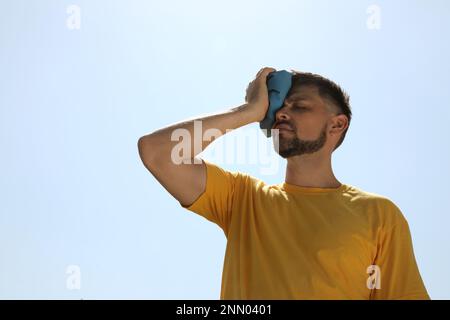 Homme avec le bloc froid souffrant de coup de chaleur à l'extérieur Banque D'Images