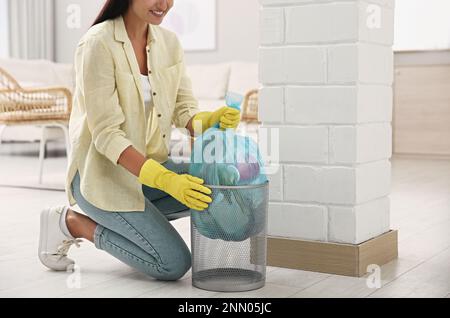 Femme prenant le sac à ordures hors de la poubelle à la maison, gros plan Banque D'Images