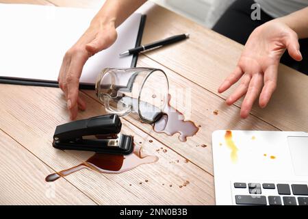 Une femme a renversé du café sur un bureau en bois, à proximité Banque D'Images